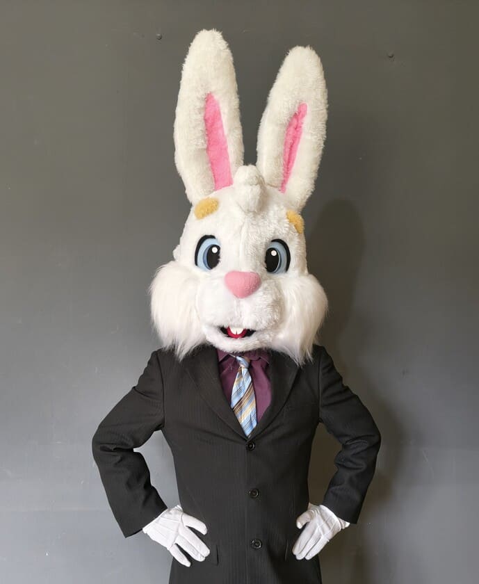 Coelho mascote com terno e gravata e luva branca na mão