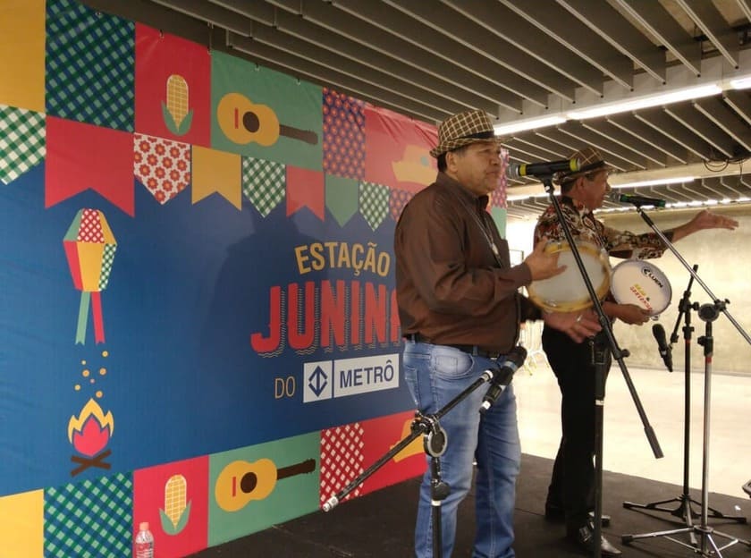 Repentistas nordestinos se apresentando em evento junino com pandeiro e improviso ao vivo