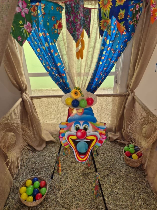 Jogo boca de palhaço para festa junina com decoração típica e bolas coloridas