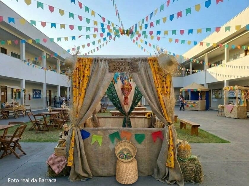 Barraca em ambiente junino com bandeirinhas de festa e colorida