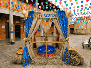 Barraca de pescaria para festa junina com placa decorativa e piscina azul em evento