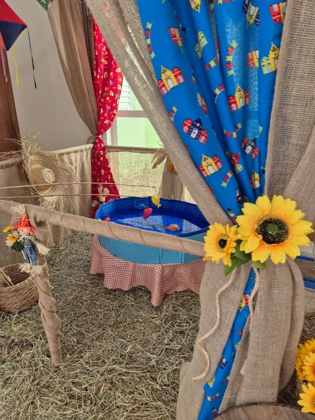 Detalhe de barraca de festa junina com tecido de chita colorido e girassol decorativo