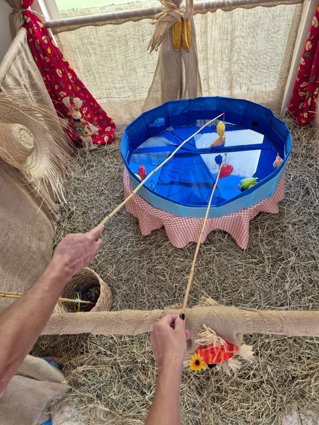 Pessoa brincando de jogo de argolas em festa junina com piscina azul decorada