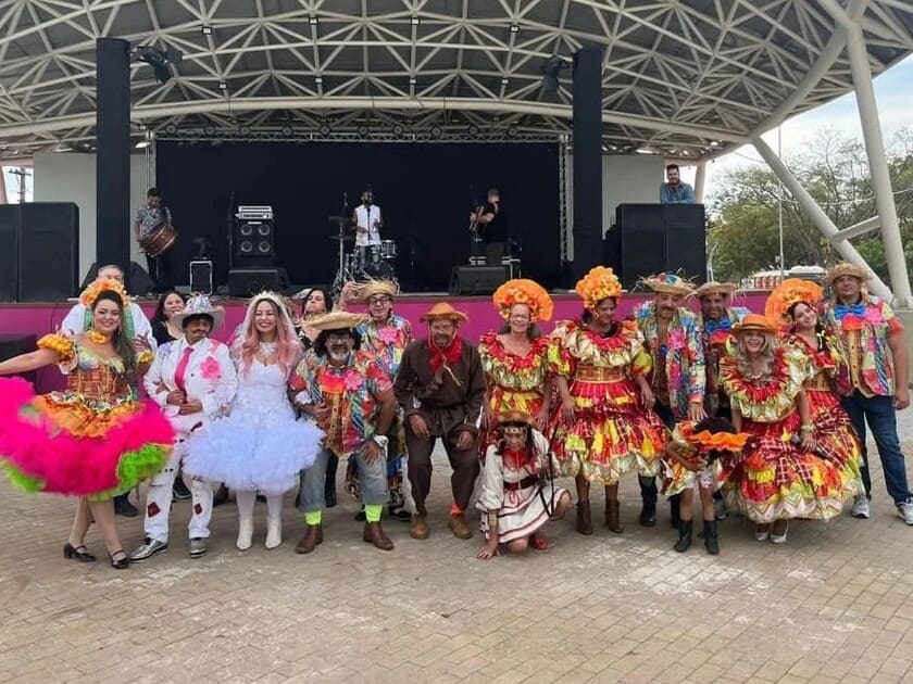 Quadrilha para festa junina com grupo de dançarinos vestidos de caipira em apresentação em palco para evento