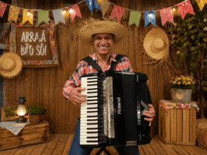 Sanfoneiro tocando acordeon em cenário decorado para Festa Junina e quermesse, atração musical para eventos
