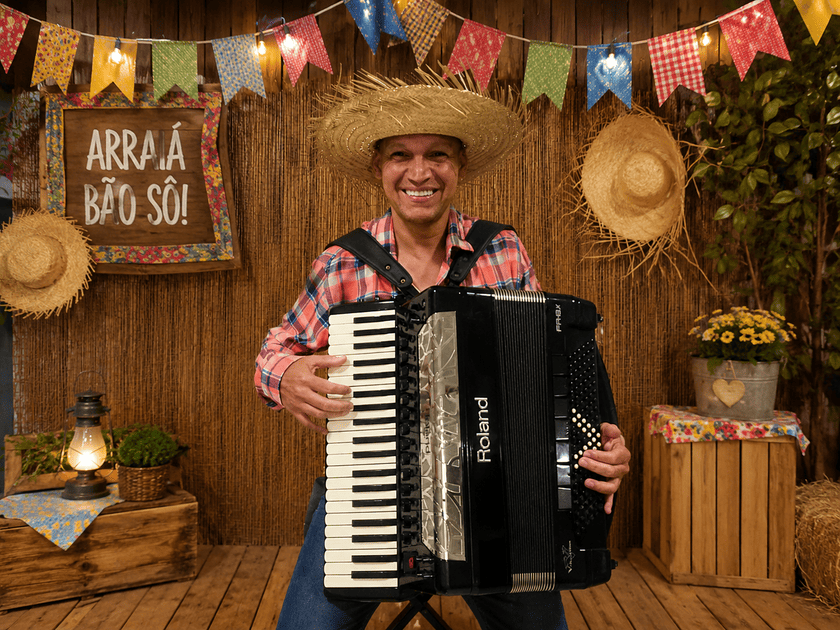 Sanfoneiro tocando acordeon em cenário decorado para Festa Junina e quermesse, atração musical para eventos