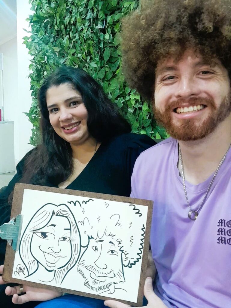 Casal exibindo caricatura feita ao vivo como lembrança personalizada de evento