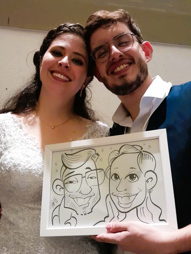 casal de noivos segurando suas caricaturas