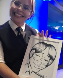 Jovem bartender de oculos segurando sua caricatura em um evento corporativo