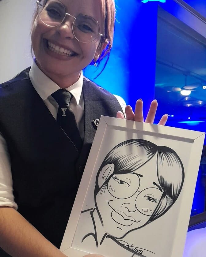 Jovem bartender de oculos segurando sua caricatura
