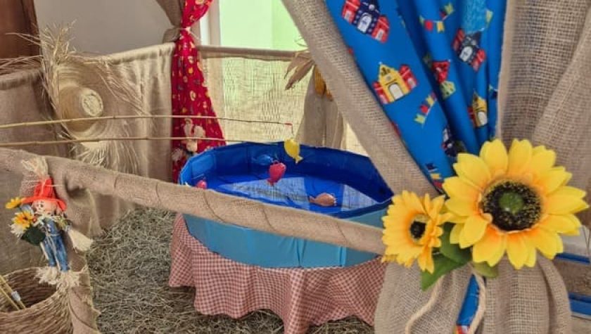 Detalhe de barraca de festa junina com tecido de chita colorido e girassol decorativo