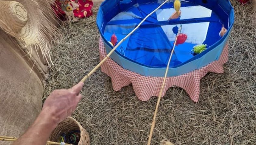 Pessoa brincando de jogo de argolas em festa junina com piscina azul decorada